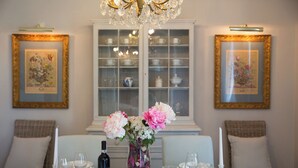 A dining table set with glassware, a bottle, and a vase with flowers.