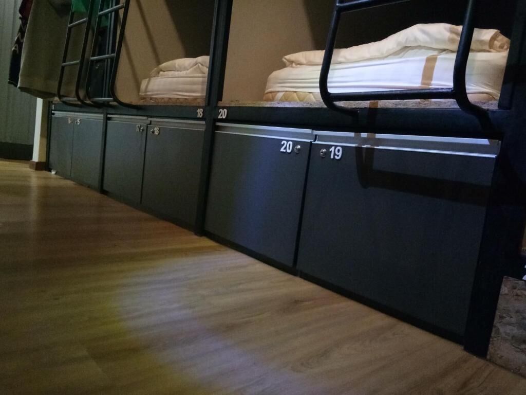 Camas literas con los números 19 y 20, suelo de madera y una ventana con vistas.