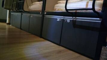 Camas literas con los números 19 y 20, suelo de madera y una ventana con vistas.