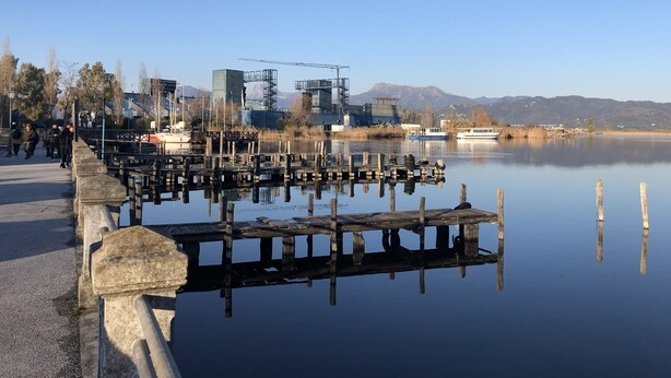 A calm lake with wooden docks and a bridge. - Villa in Torre del Lago /Viareggio a stone's throw from the lake theater near the Sea  (Torre del Lago Puccini)