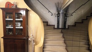 A grand staircase with a curved wall and a wooden cabinet with glass doors. - Villa in Torre del Lago /Viareggio a stone's throw from the lake theater near the Sea  (Torre del Lago Puccini)