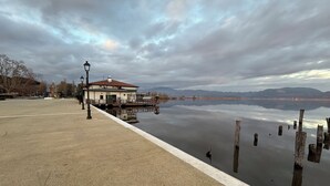 A waterfront area with a building, a dock, and a calm body of water. - Villa in Torre del Lago /Viareggio a stone's throw from the lake theater near the Sea  (Torre del Lago Puccini)