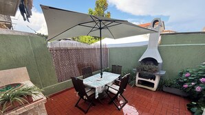 A patio with a table and chairs, a grill, and a potted plant. - Villa in Torre del Lago /Viareggio a stone's throw from the lake theater near the Sea  (Torre del Lago Puccini)