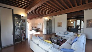 A spacious living area with a white sofa, a glass coffee table, and a bookshelf. - EXCLUSIVE CHIANTI VILLA SPECTACULAR POOL TENNIS COURT 15 MIN TOFLORENCE   (IMPRUNETA)