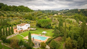 A villa with a swimming pool surrounded by lush greenery and hills. - EXCLUSIVE CHIANTI VILLA SPECTACULAR POOL TENNIS COURT 15 MIN TOFLORENCE   (IMPRUNETA)