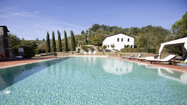 A clear swimming pool with lounge chairs and a white building in the background. - EXCLUSIVE CHIANTI VILLA SPECTACULAR POOL TENNIS COURT 15 MIN TOFLORENCE   (IMPRUNETA)