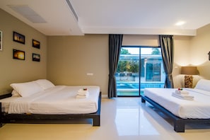 Habitación de hotel con dos camas, un ventanal con vista a una piscina y un ventilador de techo.