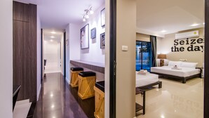A modern hotel room with a bed, bedside table, and a large window. There are wooden stools in the hallway and a wall with a motivational quote. - Sierra Pool Villa Hua Hin 102 (Hua Hin)