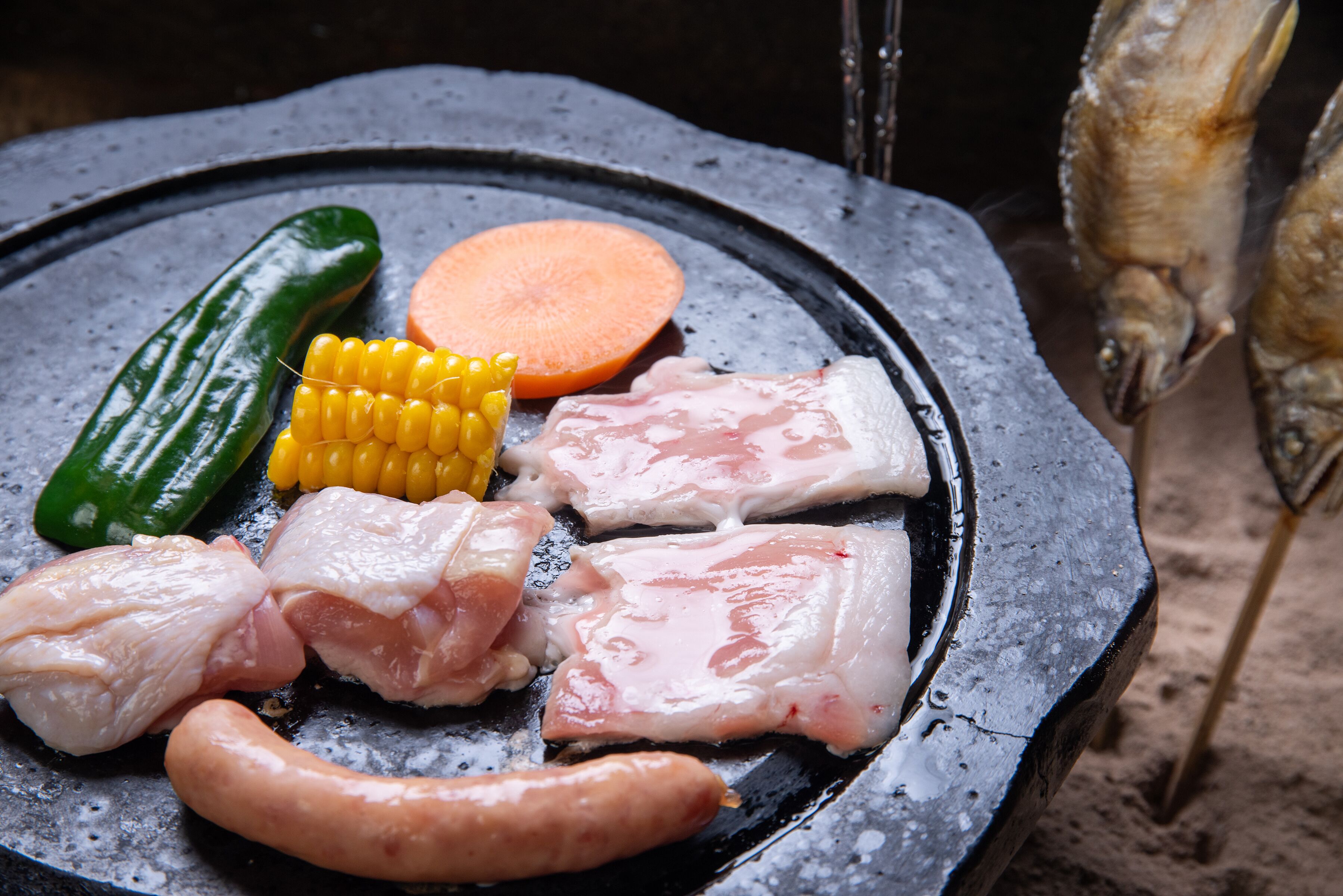 A grill with various meats and vegetables.