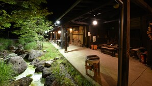 Ein traditionelles japanisches Ryokan mit Tatami-Matten, einer Steintorii und einem Teich mit Koi-Karpfen.
