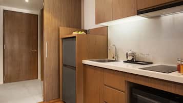 Une cuisine moderne avec des meubles en bois, un évier en acier inoxydable et un four encastré.
