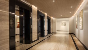 A modern hallway with wooden flooring, black and beige walls, and recessed lighting. - Hotel Emion Phnom Penh (Phnom Penh)