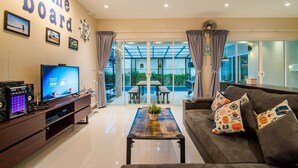 Uma sala de estar moderna com televisão, colunas e uma mesa de centro.