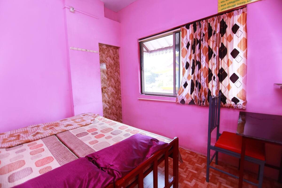 A room with a bed, a desk, and a chair.