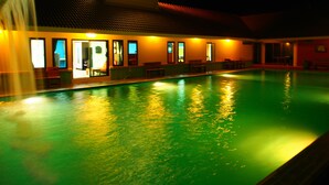 Una piscina con zona cubierta y asientos.