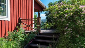 A red wooden building with a wooden staircase leading up to a porch.