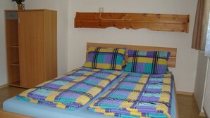 Un dormitorio con cama, un armario de madera y cabecero de madera.