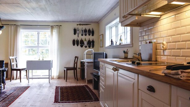 A kitchen with white cabinets, a wooden countertop, and a window with curtains. - 1 bedroom amazing home in Borgholm (Borgholm)