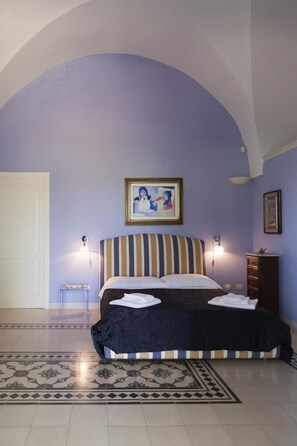 A bedroom with a bed, a painting, a dresser, and a chair. - Villa Urso BedWine (Lecce)