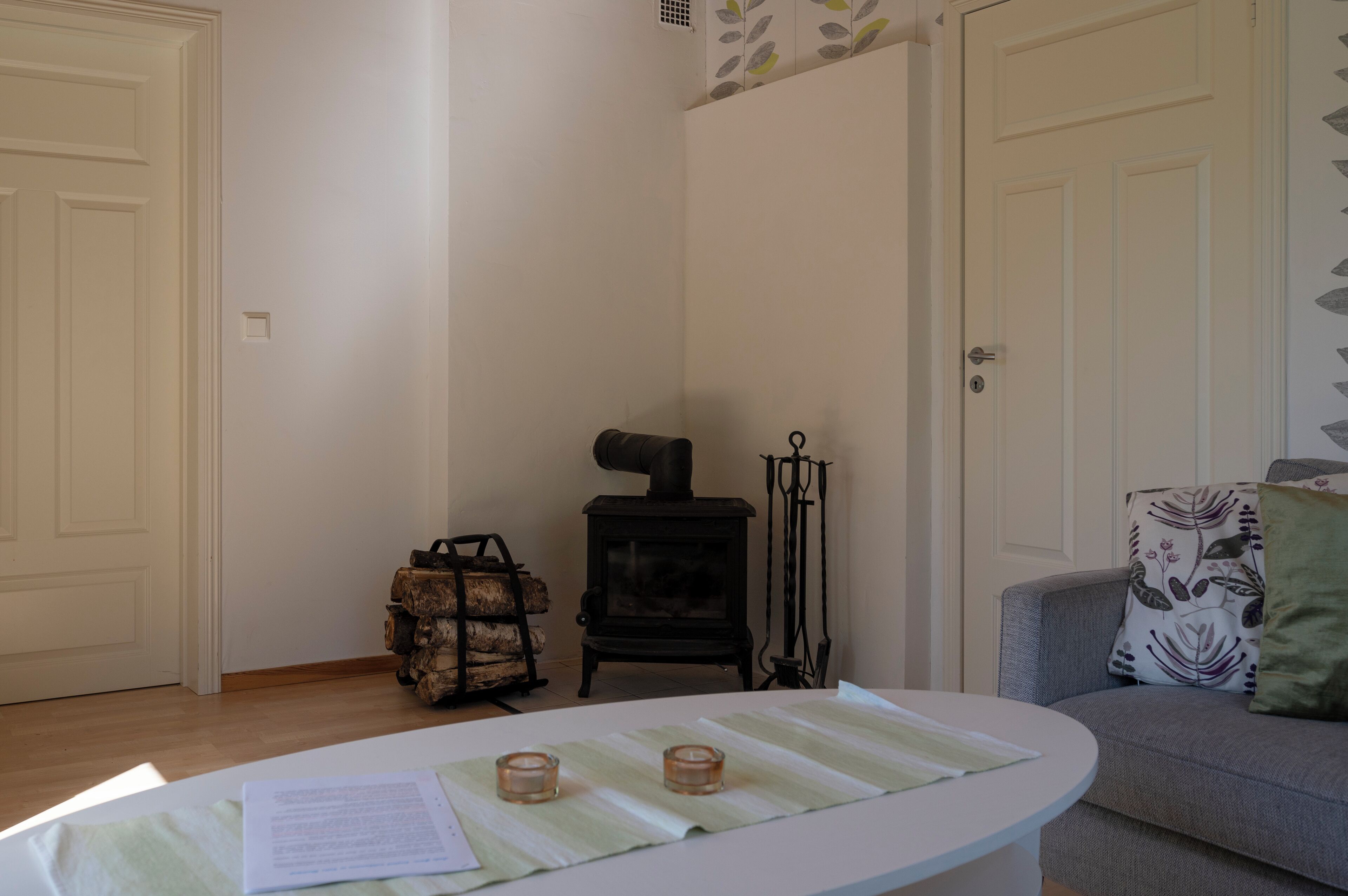 Un salon chaleureux avec une cheminée, un canapé et une table décorée de bougies.