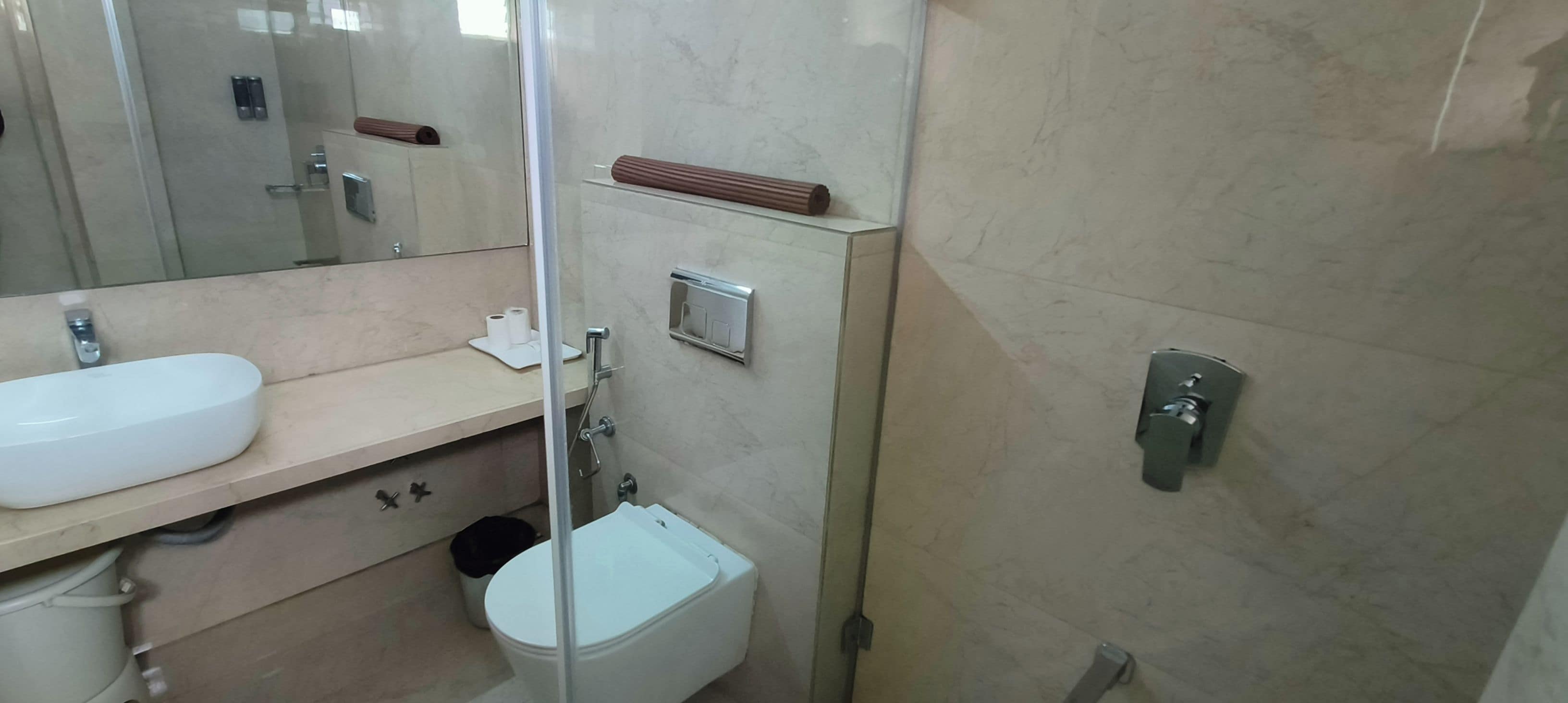 A bathroom with a white sink, a toilet, and a mirror.