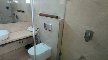 A bathroom with a white sink, a toilet, and a mirror.