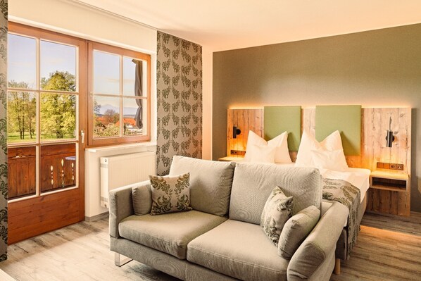 Relax in this serene bedroom with a large bed, sofa, and natural views.