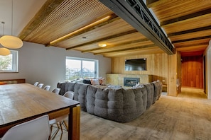A spacious living area with a wooden ceiling, a large seating area, and a fireplace. - Le Chalets (Falls Creek)