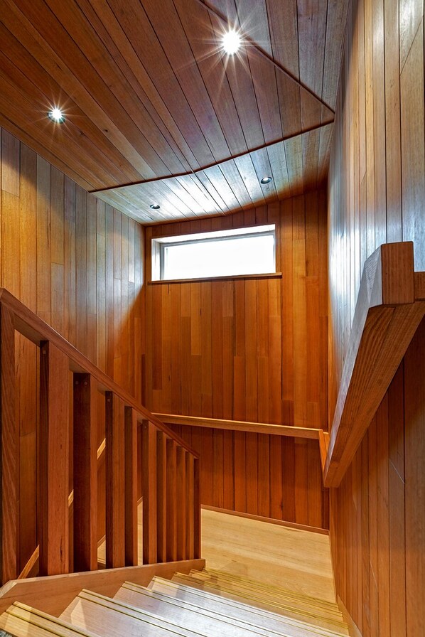 A wooden interior with a staircase, a skylight, and a wooden railing. - Le Chalets (Falls Creek)