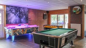 A billiards room with a pool table, foosball table, and a mural on the wall. - 3 bedroom nice home in Vledder (Vledder)