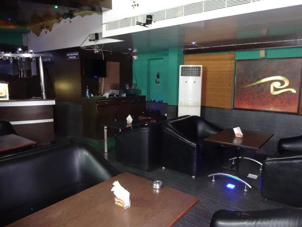 Un área de bar moderna con asientos de cuero, una barra y un equipo de aire acondicionado grande.