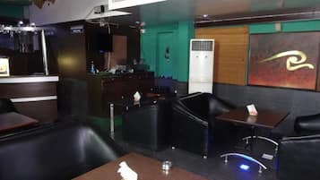 Un área de bar moderna con asientos de cuero, una barra y un equipo de aire acondicionado grande.