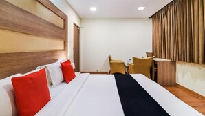 A hotel room with a large bed, a desk, and a chair. - Grand Plaza (Coimbatore)