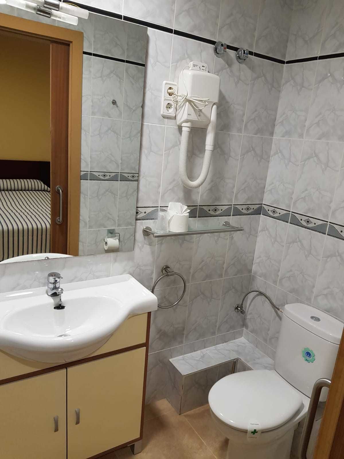 Un baño con lavamanos, inodoro y ducha.