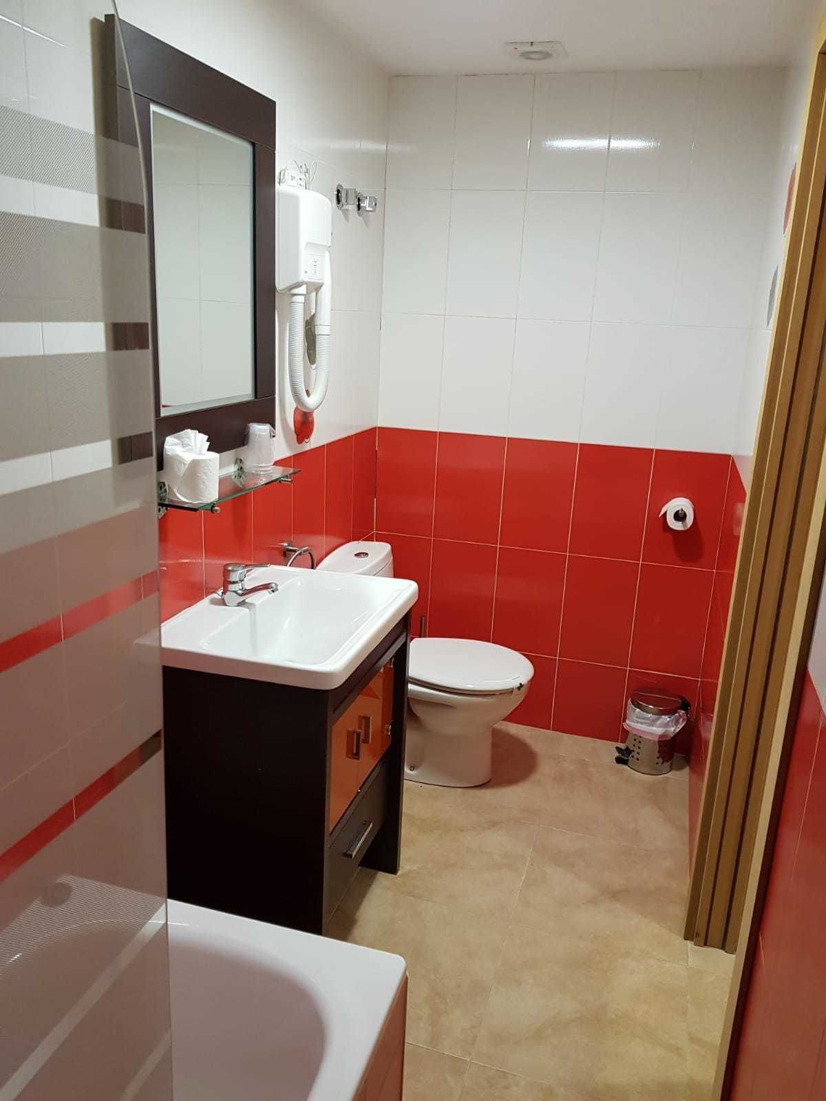 Un baño con un lavabo blanco, un inodoro y una zona de ducha.