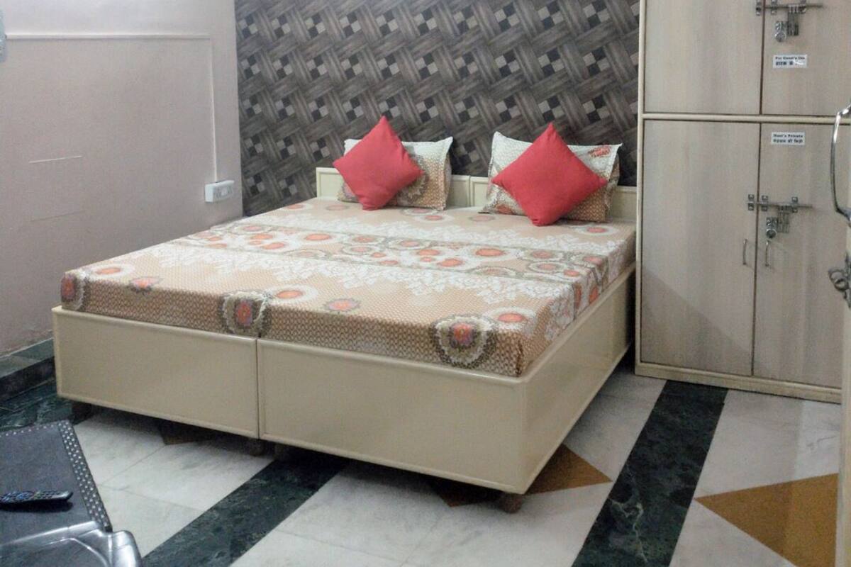 A bedroom with a bed, a wardrobe, and a ceiling fan.