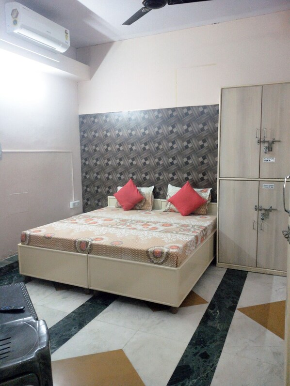 Un dormitorio con cama, armario y ventilador de techo.