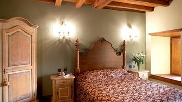Un dormitorio con una cama de madera, dos mesitas de noche, un armario y una lámpara de pared.