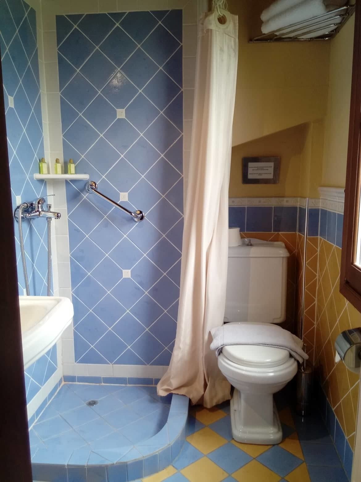 A bathroom with a shower, toilet, and sink.