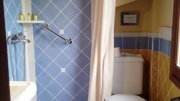 A bathroom with a shower, toilet, and sink.