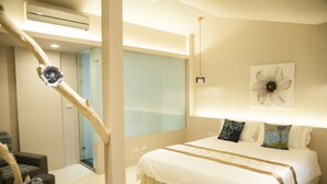 Ein Schlafzimmer mit einem großen Bett, einem Nachttisch, einem Sessel und einem an der Wand befestigten Kunstwerk.