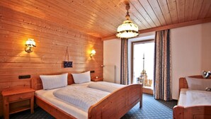 A wooden-paneled room with a double bed, two bedside tables, and a hanging light fixture. - Alpenpanorama Vacation Rental, 68 square meters, with balcony, kitchen, Wi-Fi (Ruhpolding)