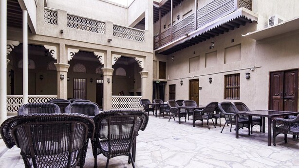 An outdoor seating area with wicker furniture and stone flooring.