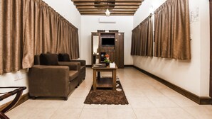 A living room with a sofa set, a coffee table, and a TV on a wooden cabinet.