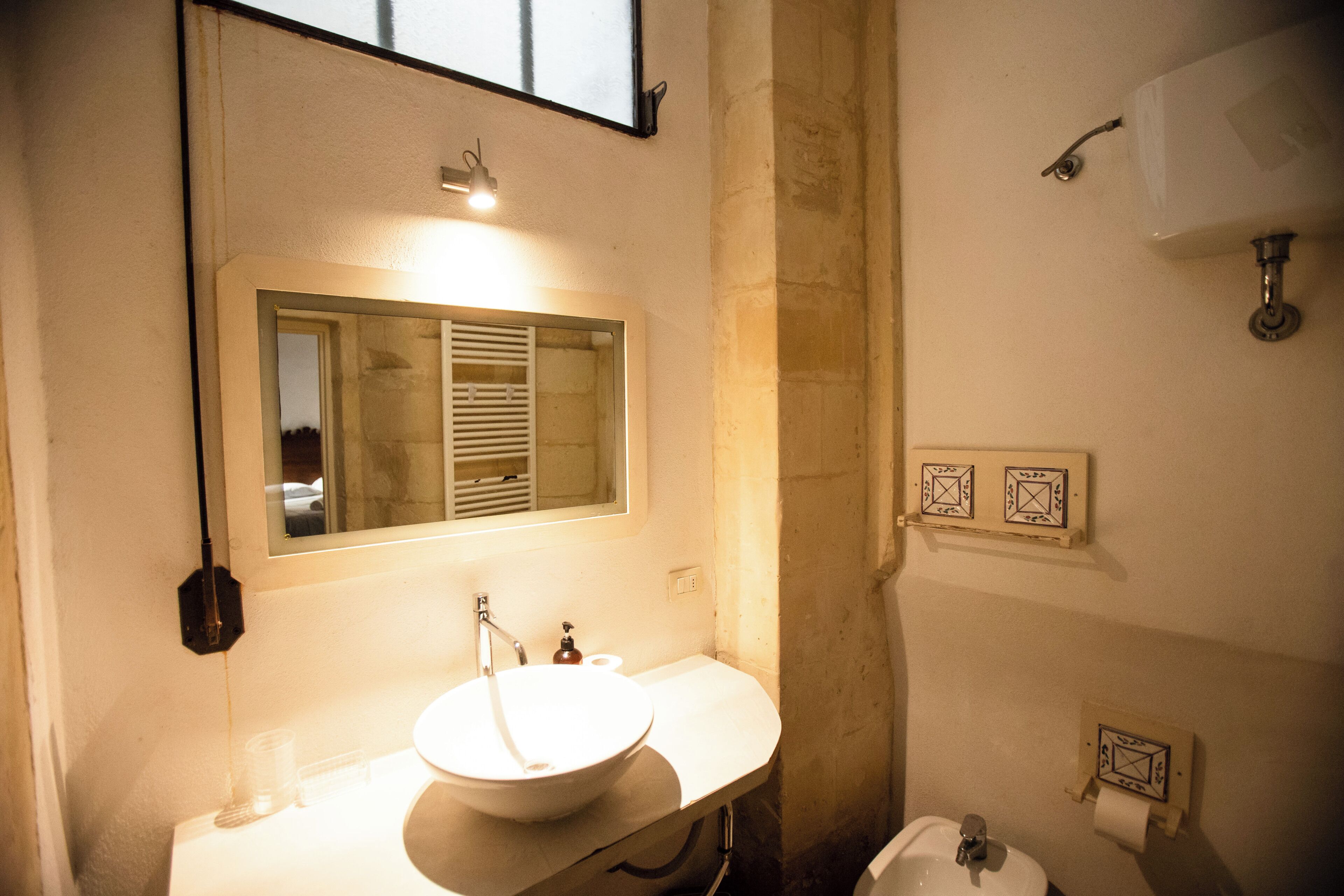 A bathroom with a sink, mirror, and toilet.