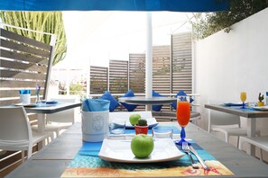 An outdoor dining area with tables, chairs, and umbrellas. - Rivazzurra Design Rooms (San Vito Lo Capo)