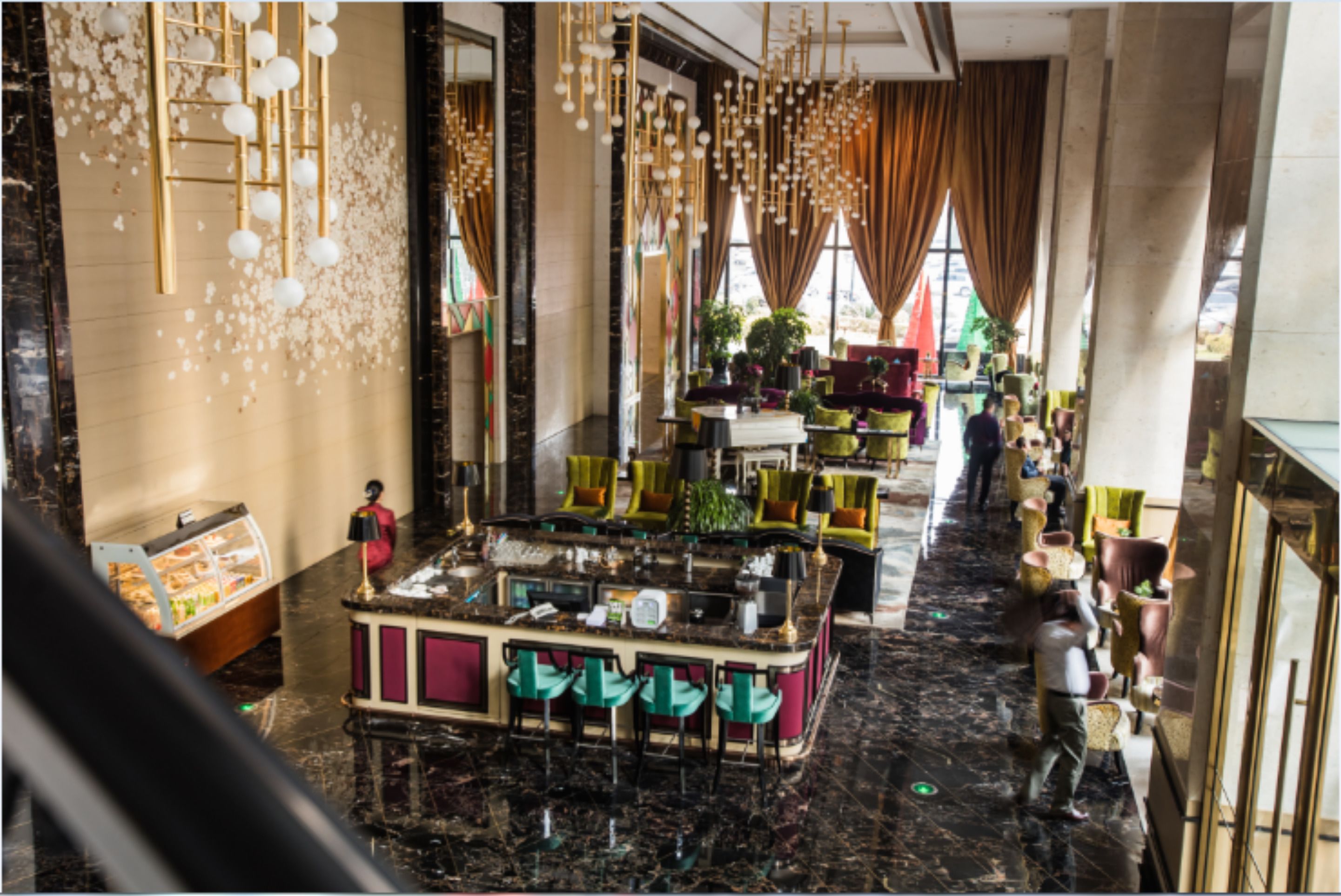 A spacious lobby with a central bar area, seating arrangements, and a display case.