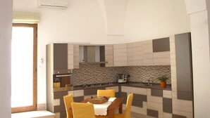Una cocina moderna con un reverso a cuadros, un comedor con sillas amarillas y un techo abovedado grande.