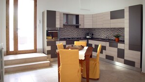 Una cocina moderna con comedor, que presenta un salpicadero a cuadros, armarios de madera y una mesa de comedor con sillas amarillas.