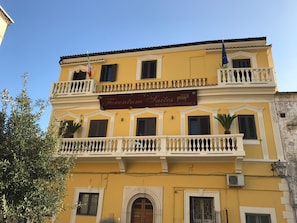 Um edifício amarelo com uma placa que diz 'Forentum Suites Residencia d'Epoca'.